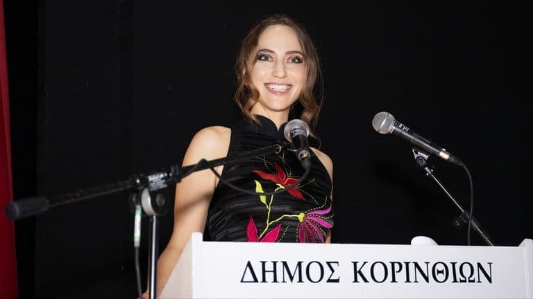 The image captures Inessa Kraft speaking at an event, embodying her role as a filmmaker and cultural ambassador for Cyprus.