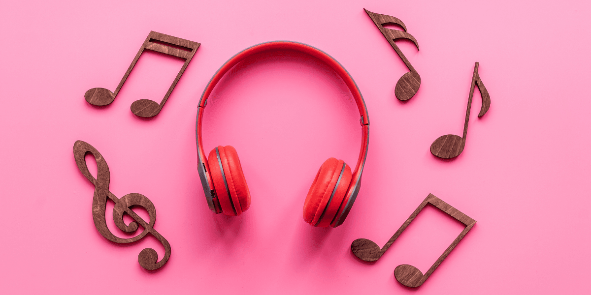 Red headphones surrounded by wooden music notes on a pink background