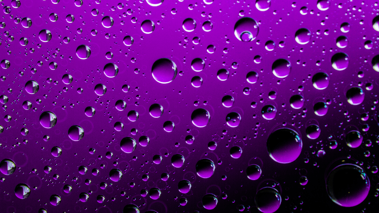 Purple water droplets on a dark background symbolizing Prince's Purple Rain.