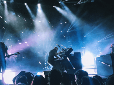 Green Day performs onstage with dramatic lighting during a live concert at Comic-Con.