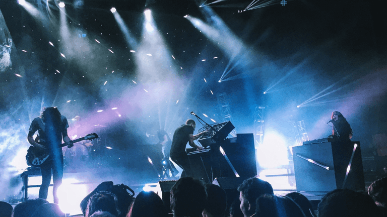 Green Day performs onstage with dramatic lighting during a live concert at Comic-Con.