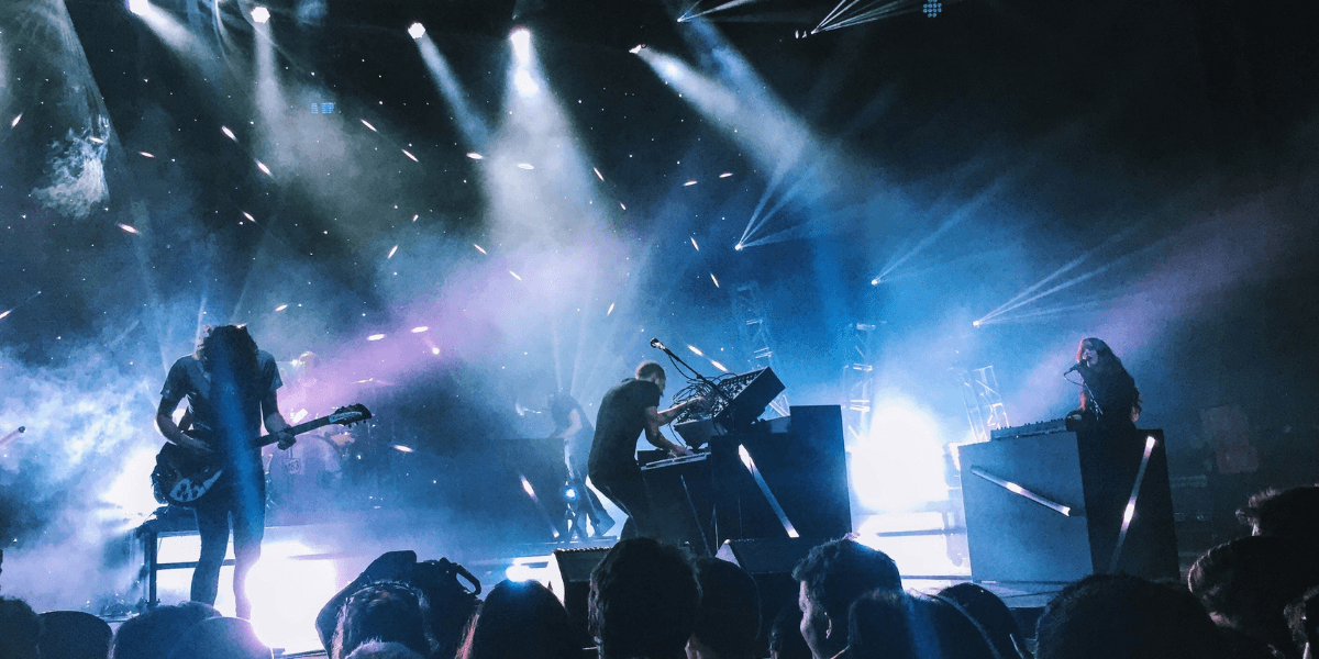Green Day performs onstage with dramatic lighting during a live concert at Comic-Con.