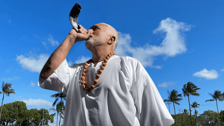 Apostle Constantine I. Nightingdale calling for transformation and spiritual awakening with a shofar.