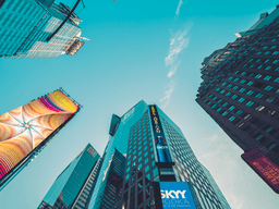Skyscrapers and billboards in an urban area against a clear blue sky