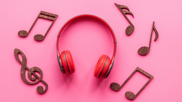 Red headphones surrounded by wooden music notes on a pink background