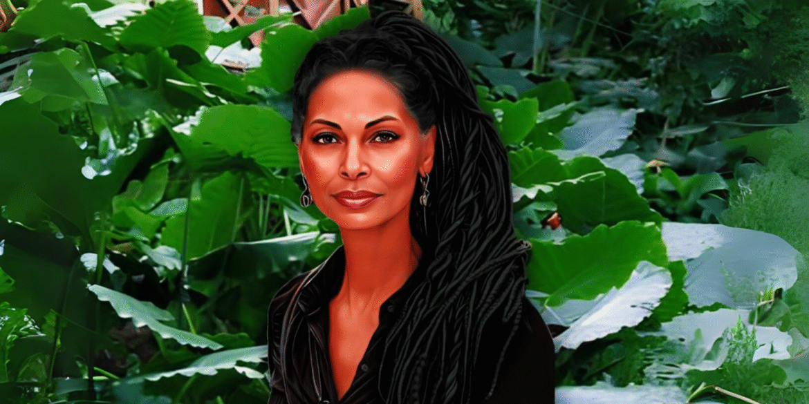 Portrait of a woman with long braids, wearing black, standing in front of lush green tropical plants.