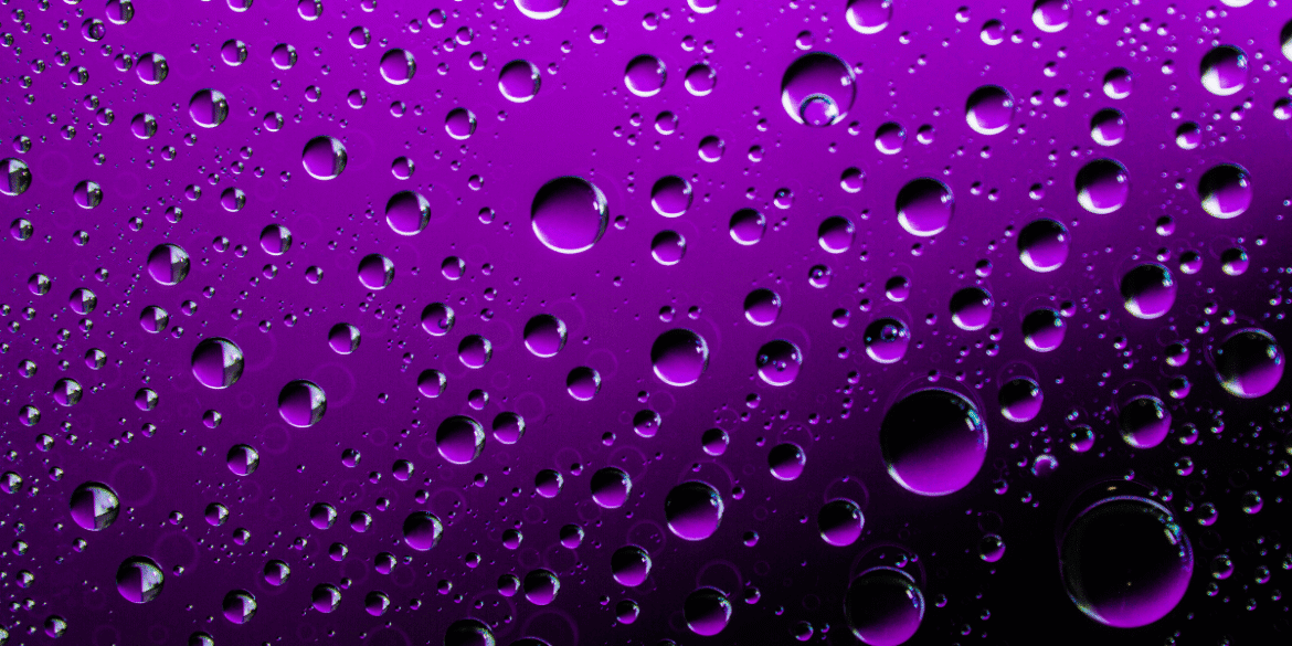 Purple water droplets on a dark background symbolizing Prince's Purple Rain.